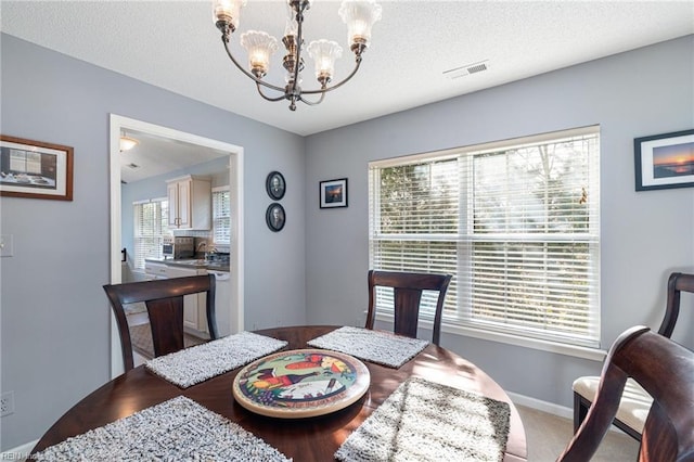 dining space with a chandelier, visible vents, and a wealth of natural light