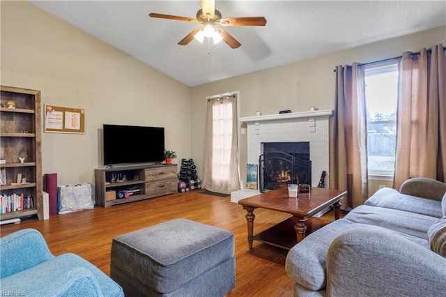 living room featuring wood finished floors, a healthy amount of sunlight, and vaulted ceiling