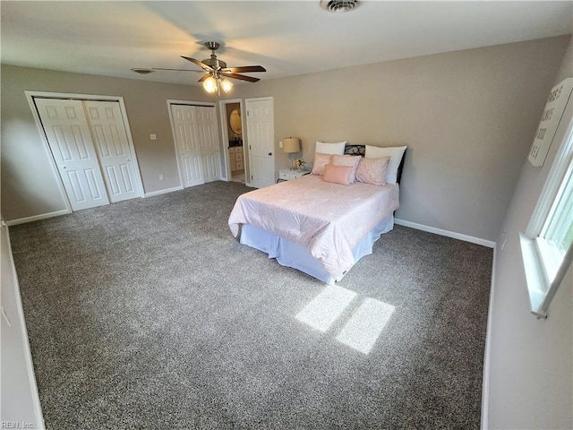 bedroom with ceiling fan, carpet floors, visible vents, baseboards, and two closets