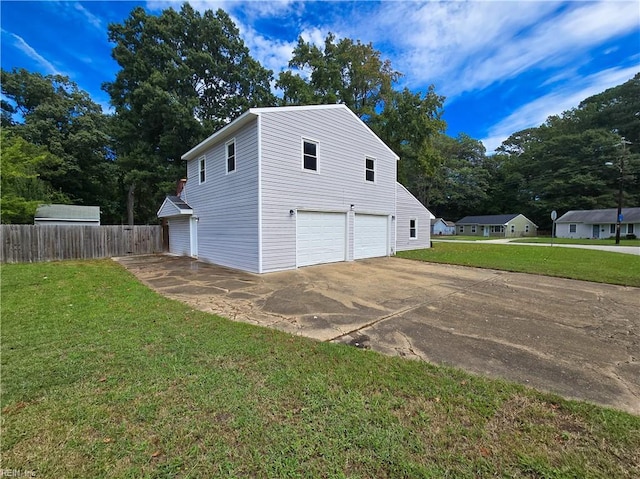 garage with concrete driveway and fence