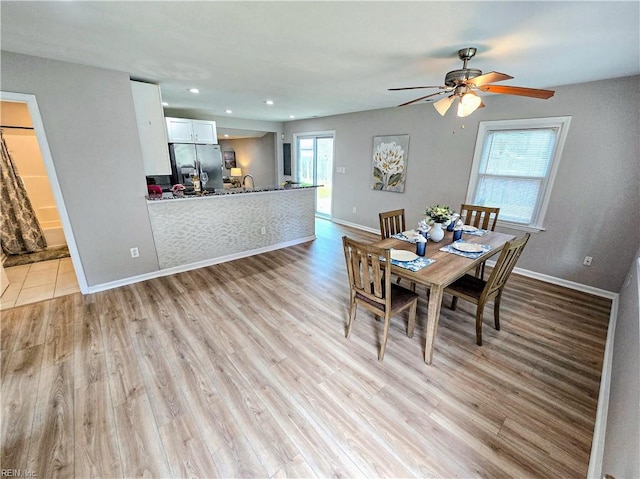 dining area with light wood-style flooring, baseboards, a wealth of natural light, and recessed lighting