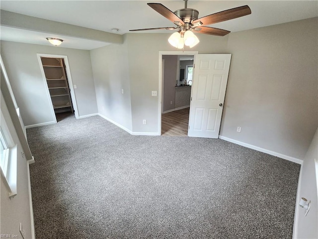 carpeted spare room with ceiling fan and baseboards