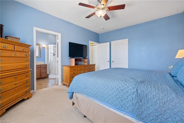 bedroom with light carpet, ceiling fan, and ensuite bathroom