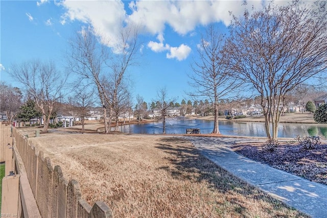 view of yard with a water view and fence