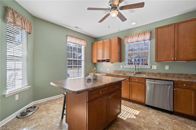 kitchen featuring a breakfast bar area, a sink, a kitchen island, dishwasher, and brown cabinetry