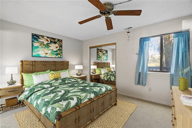 bedroom with a closet, light colored carpet, visible vents, a ceiling fan, and baseboards