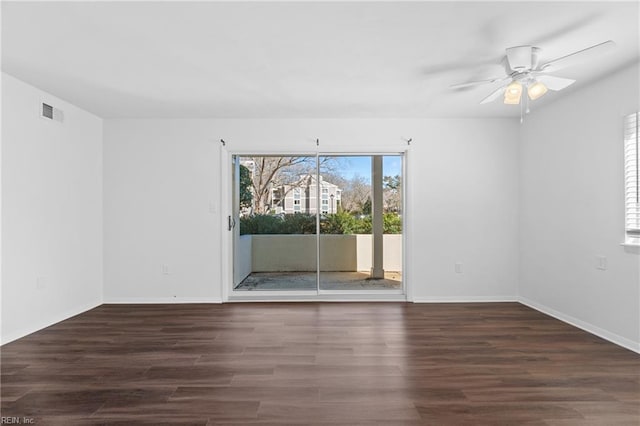 empty room with a ceiling fan, baseboards, visible vents, and wood finished floors