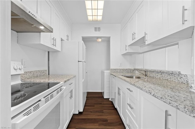 kitchen featuring white appliances, dark wood-type flooring, under cabinet range hood, white cabinetry, and a sink