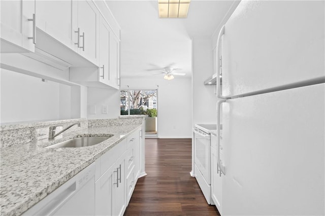 kitchen with white appliances, dark wood finished floors, light stone counters, white cabinetry, and a sink