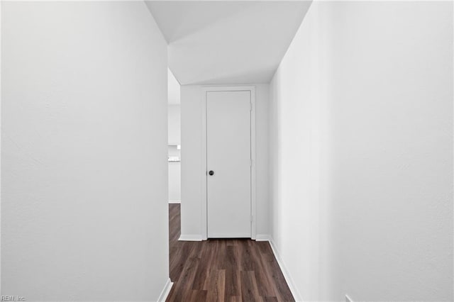 hallway with baseboards and dark wood-style flooring