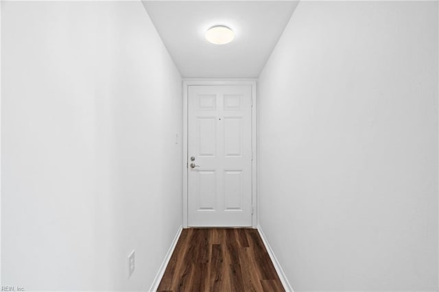 doorway featuring baseboards and dark wood finished floors