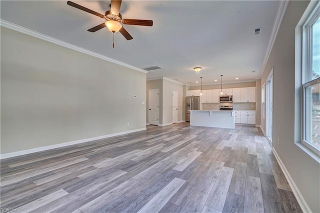 unfurnished living room featuring baseboards, light wood-style floors, visible vents, and crown molding