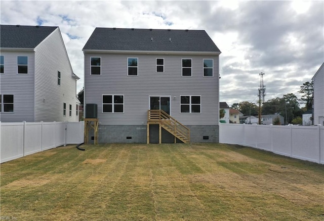 rear view of house with a fenced backyard, stairway, and a yard