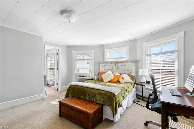 bedroom featuring multiple windows, baseboards, ornamental molding, and light colored carpet