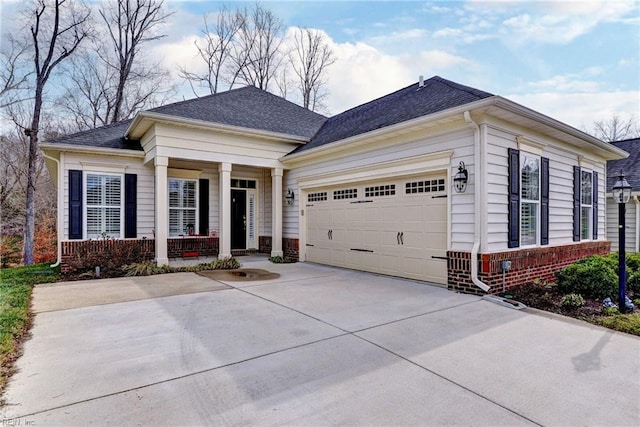 view of front of house with a garage, driveway, a shingled roof, a porch, and brick siding