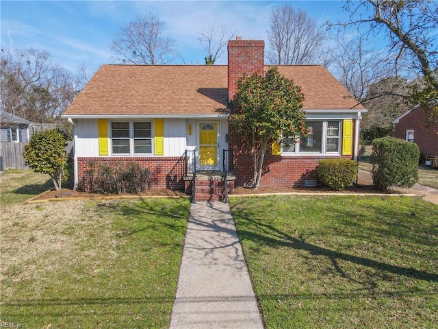 view of front of property featuring a shingled roof, a chimney, and brick siding