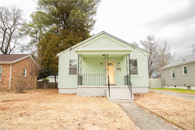 bungalow-style home featuring a porch and fence