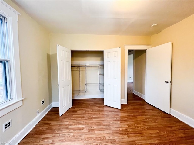 unfurnished bedroom with light wood finished floors, a closet, and baseboards