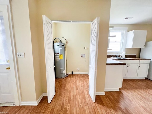 interior space with visible vents, a sink, and electric water heater