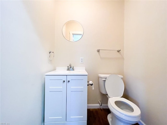 bathroom with baseboards, vanity, toilet, and wood finished floors