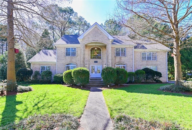 view of front of home with french doors, a front lawn, and brick siding