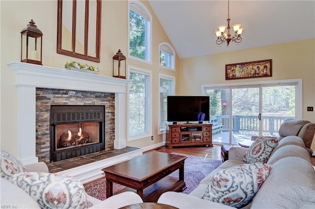 living room featuring high vaulted ceiling, a wealth of natural light, a fireplace, and wood finished floors