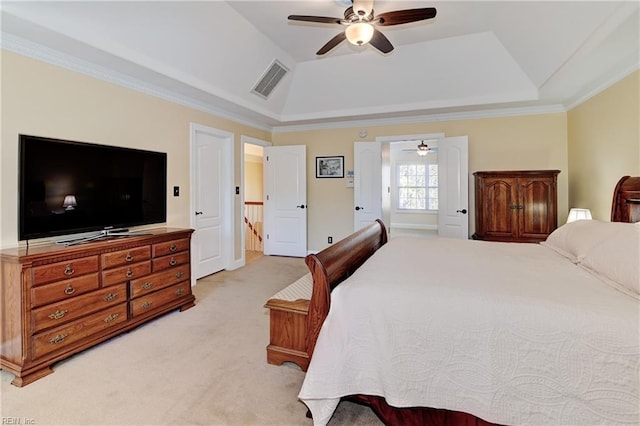 bedroom featuring ceiling fan, light colored carpet, visible vents, a tray ceiling, and crown molding