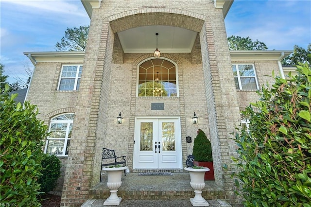 view of exterior entry with brick siding and french doors