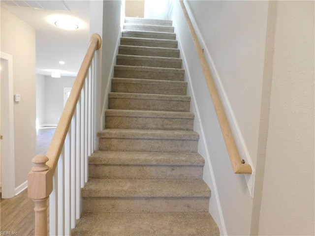 staircase featuring recessed lighting, wood finished floors, and baseboards