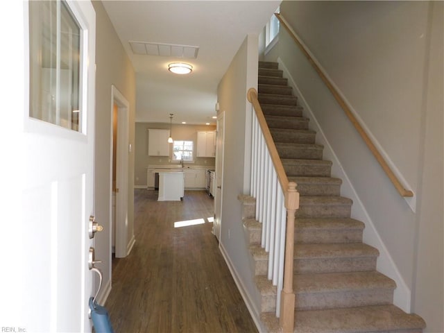 staircase with wood finished floors and visible vents