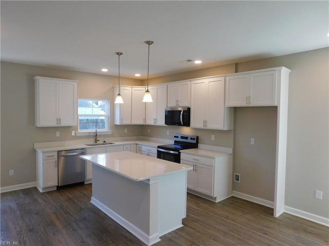 kitchen with white cabinets, dark wood-style floors, stainless steel appliances, and a sink