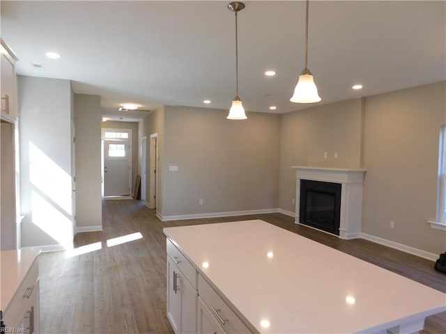 kitchen featuring a fireplace, white cabinets, dark wood-style flooring, and light countertops