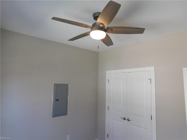 interior space with electric panel, a ceiling fan, and a closet