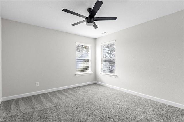 spare room featuring a ceiling fan, carpet flooring, visible vents, and baseboards