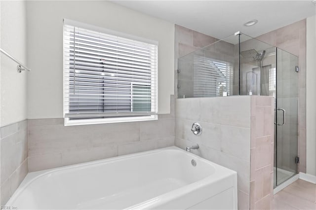 full bathroom featuring a stall shower and a garden tub