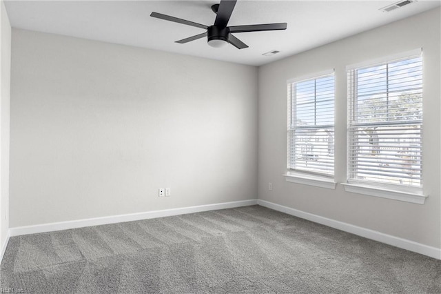 unfurnished room with carpet floors, baseboards, visible vents, and a ceiling fan