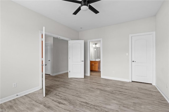 unfurnished bedroom featuring light wood-type flooring, baseboards, and ensuite bathroom