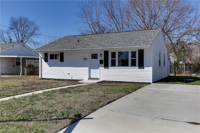 ranch-style house with a front yard and roof with shingles