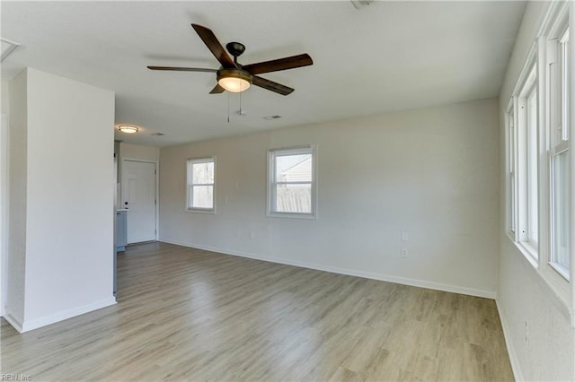 unfurnished room with baseboards, ceiling fan, and light wood-style floors