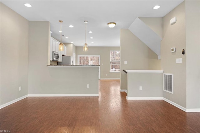 interior space with baseboards, visible vents, wood finished floors, and recessed lighting