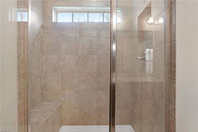 full bath featuring a stall shower and a textured wall