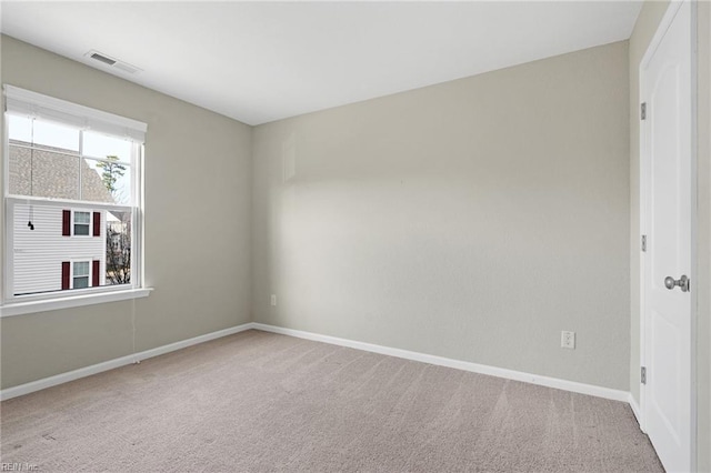 unfurnished room featuring carpet floors, visible vents, and baseboards