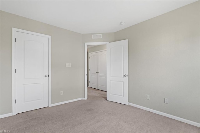 unfurnished bedroom with baseboards, visible vents, and light colored carpet