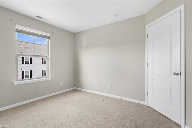 unfurnished room with carpet flooring, visible vents, and baseboards