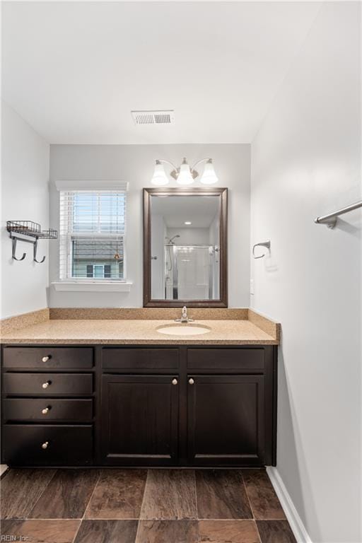 full bathroom with a stall shower, visible vents, and vanity