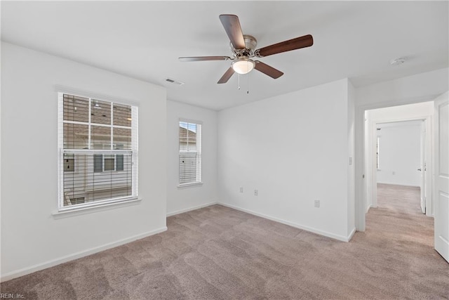 unfurnished room featuring light carpet, baseboards, visible vents, and a ceiling fan