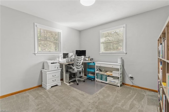 office with baseboards and light colored carpet