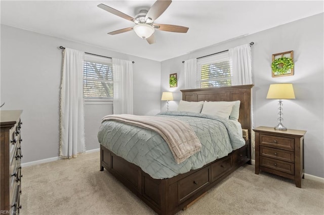 bedroom with a ceiling fan, light colored carpet, and baseboards