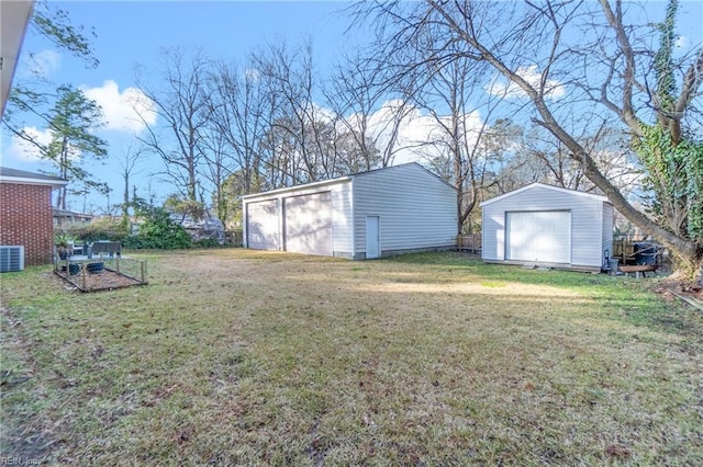 view of yard featuring an outbuilding, a storage unit, cooling unit, and a garage