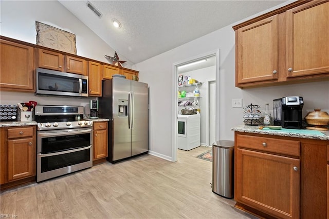 kitchen with stainless steel appliances, light wood-type flooring, brown cabinets, and light stone counters